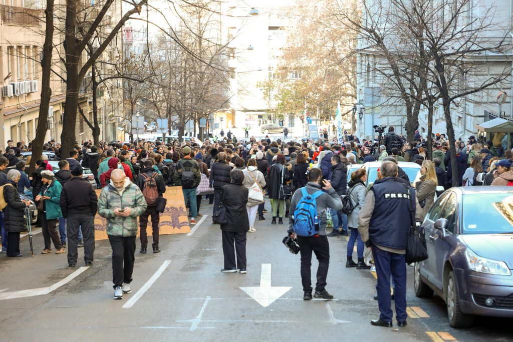 Un grand groupe de personnes s'est rassemblé dans une rue de la ville pour une manifestation en plein jour.