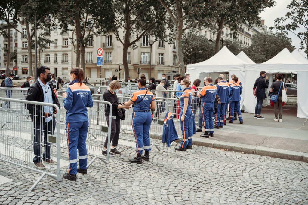 des personnes qui marchent sur le trottoir en plein jour